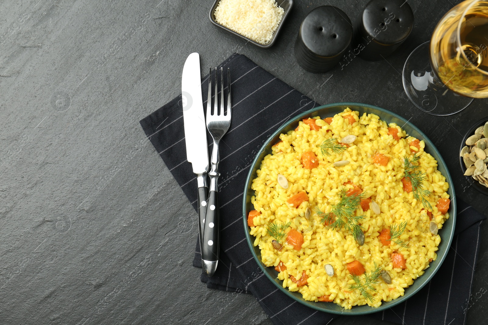 Photo of Delicious pumpkin risotto served on black table, flat lay. Space for text