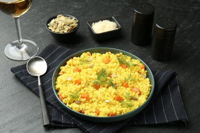 Photo of Delicious pumpkin risotto served on black table