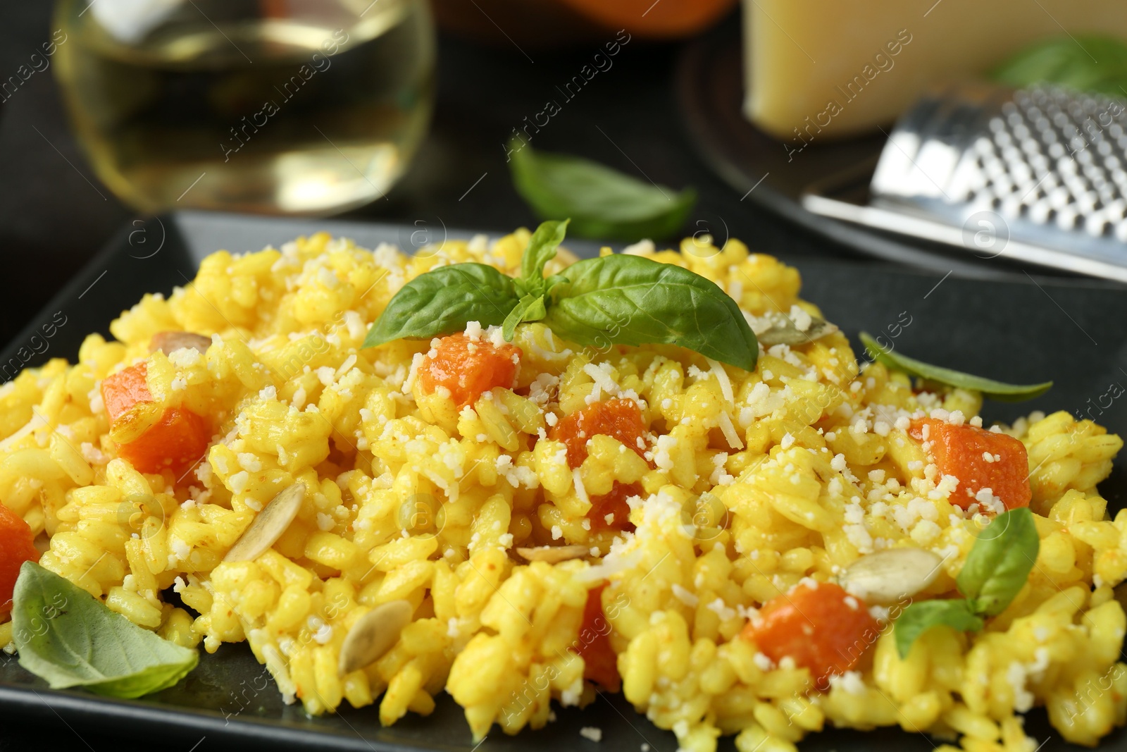 Photo of Delicious pumpkin risotto with parmesan and basil. closeup