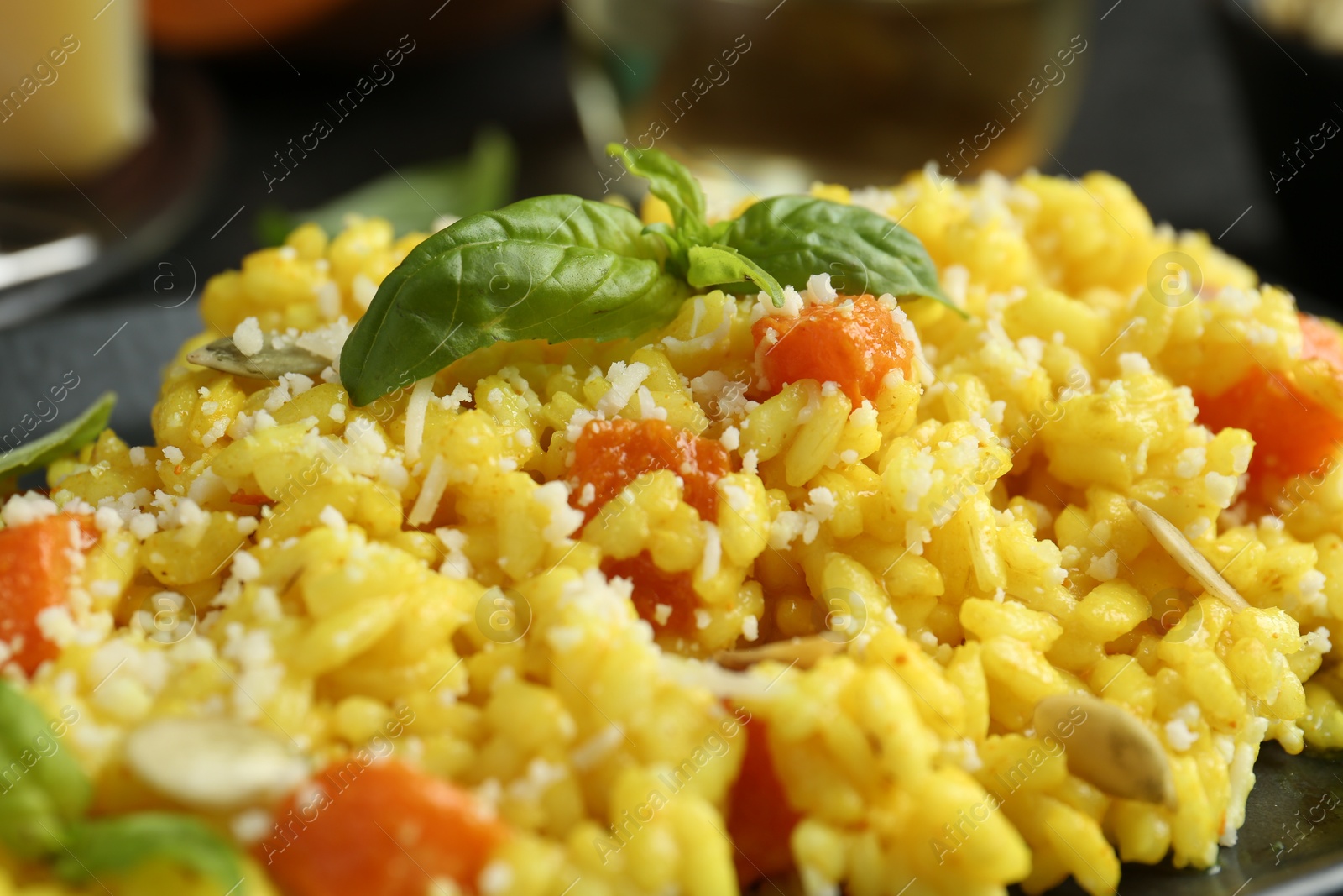 Photo of Delicious pumpkin risotto with parmesan and basil. closeup