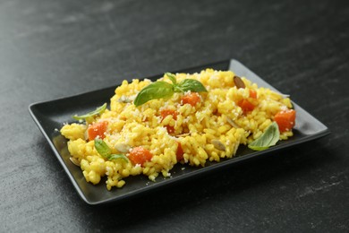 Photo of Delicious pumpkin risotto on black table, closeup