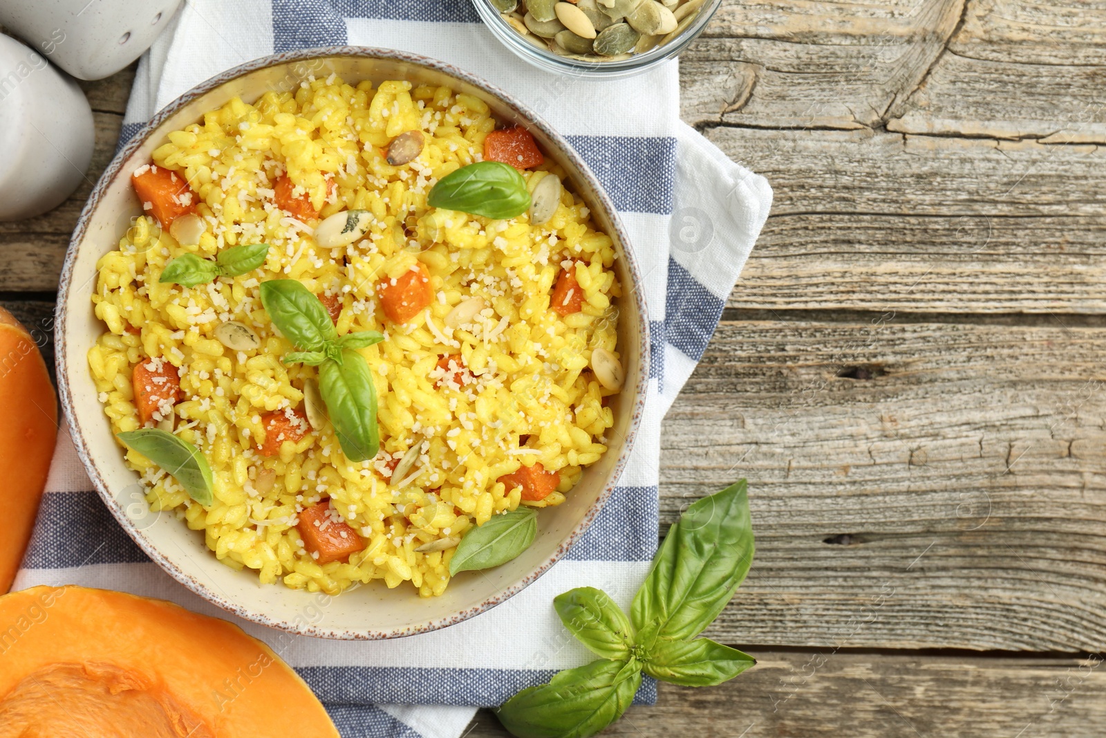 Photo of Delicious pumpkin risotto served on wooden table, flat lay. Space for text