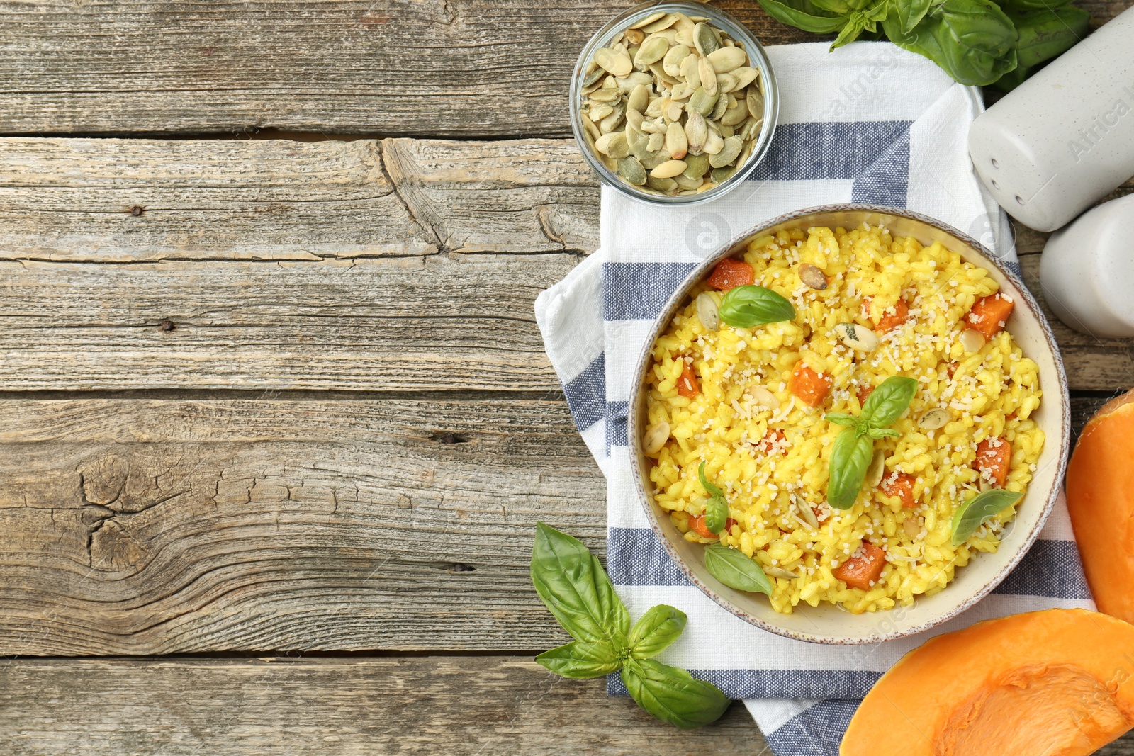 Photo of Delicious pumpkin risotto served on wooden table, flat lay. Space for text