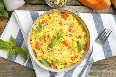 Photo of Delicious pumpkin risotto served on wooden table, flat lay