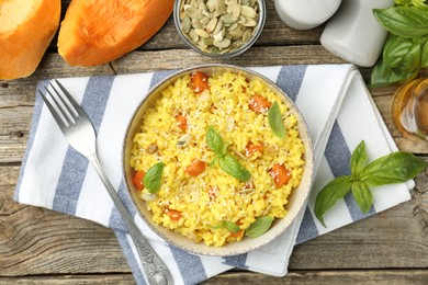 Photo of Delicious pumpkin risotto served on wooden table, flat lay