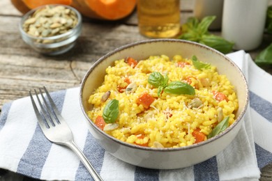 Photo of Delicious pumpkin risotto served on wooden table, closeup