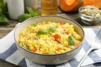 Delicious pumpkin risotto served on wooden table, closeup