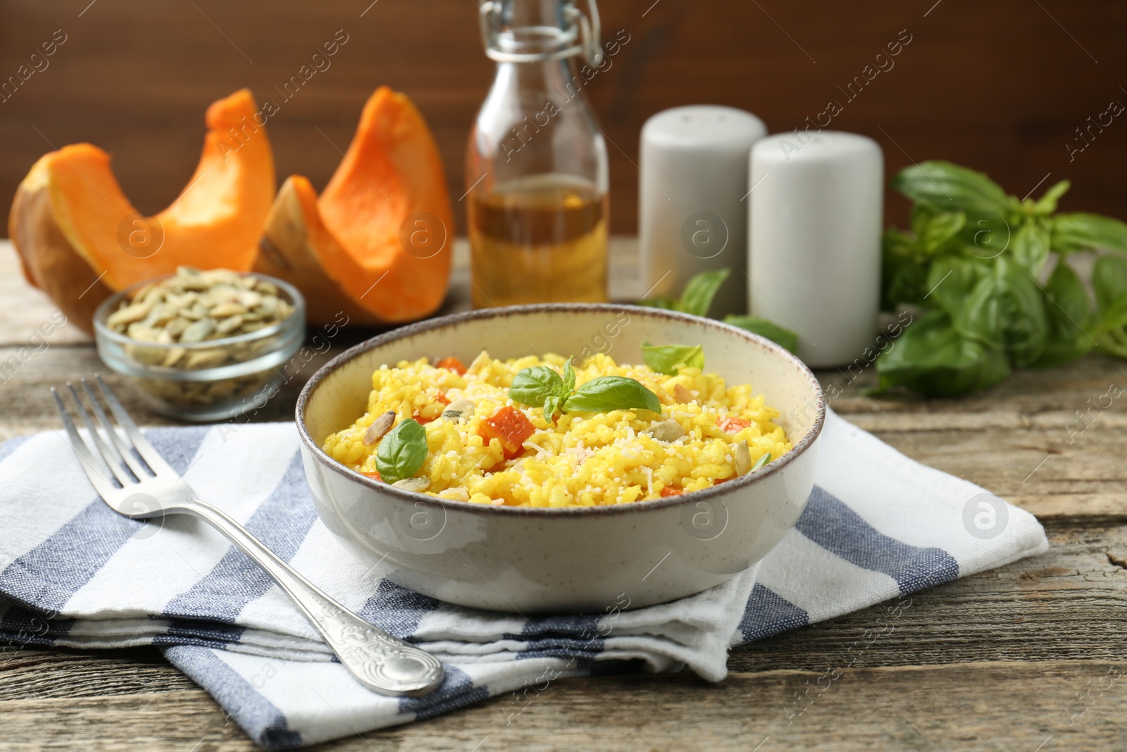 Photo of Delicious pumpkin risotto served on wooden table