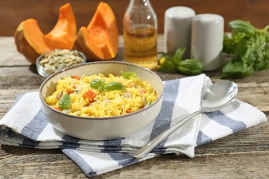 Photo of Delicious pumpkin risotto served on wooden table