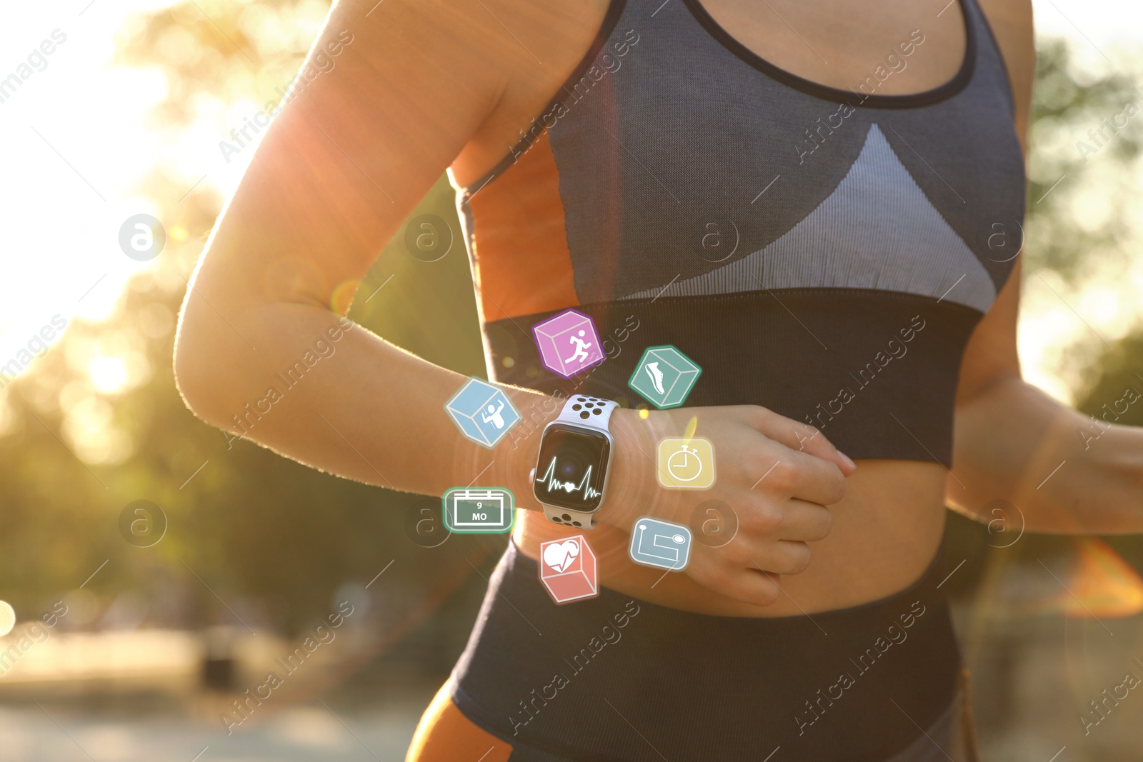 Image of Woman with smart watch running outdoors on sunny morning, closeup. Icons near device