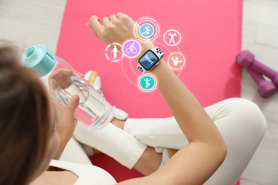 Image of Young woman using smart watch during training indoors, above view. Icons near device