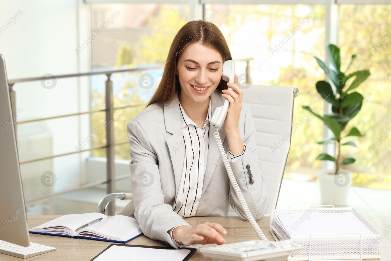 Photo of Banker talking on telephone at table in office