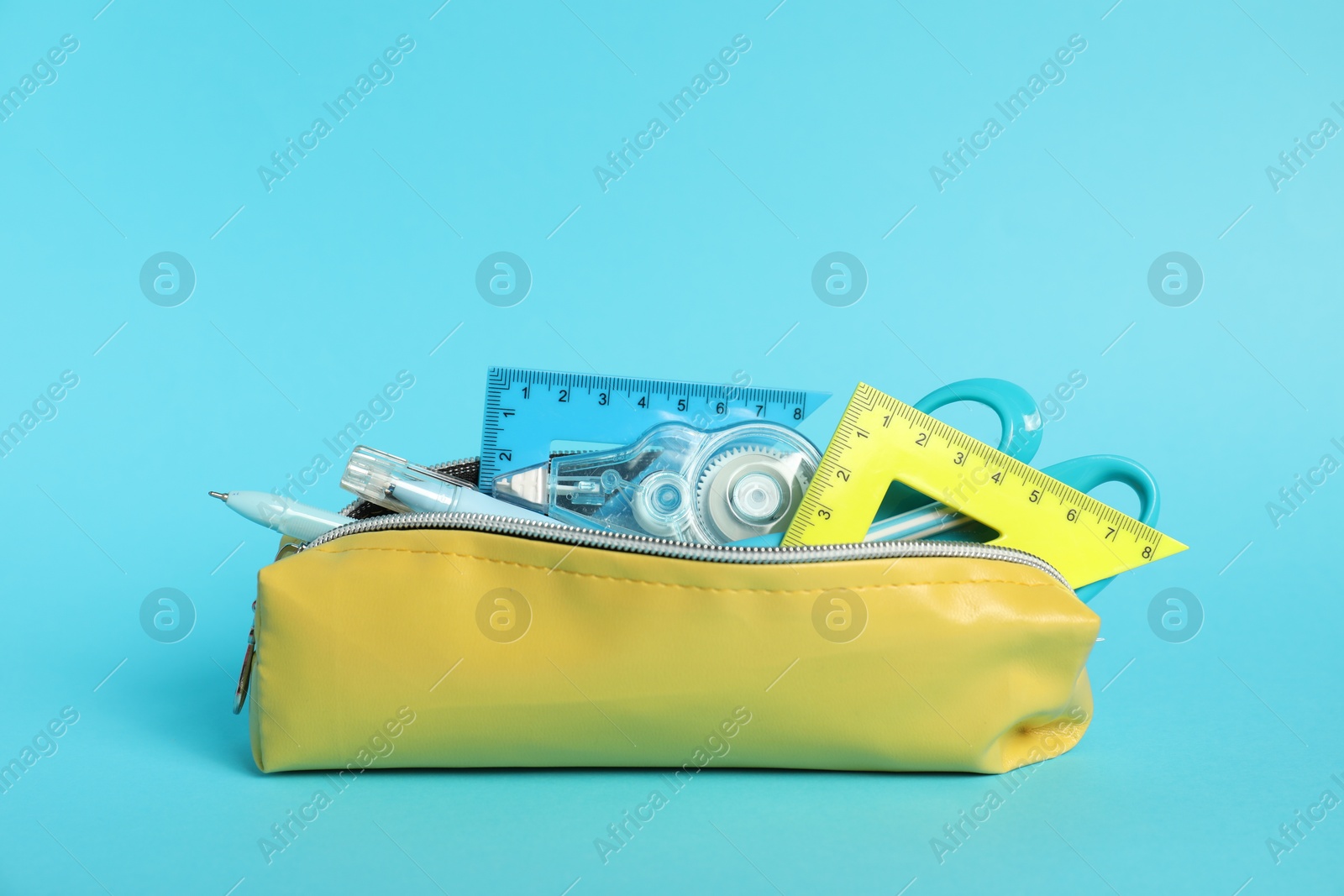 Photo of Different stationery in pencil case on light blue background