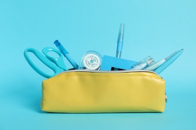 Photo of Different stationery in pencil case on light blue background