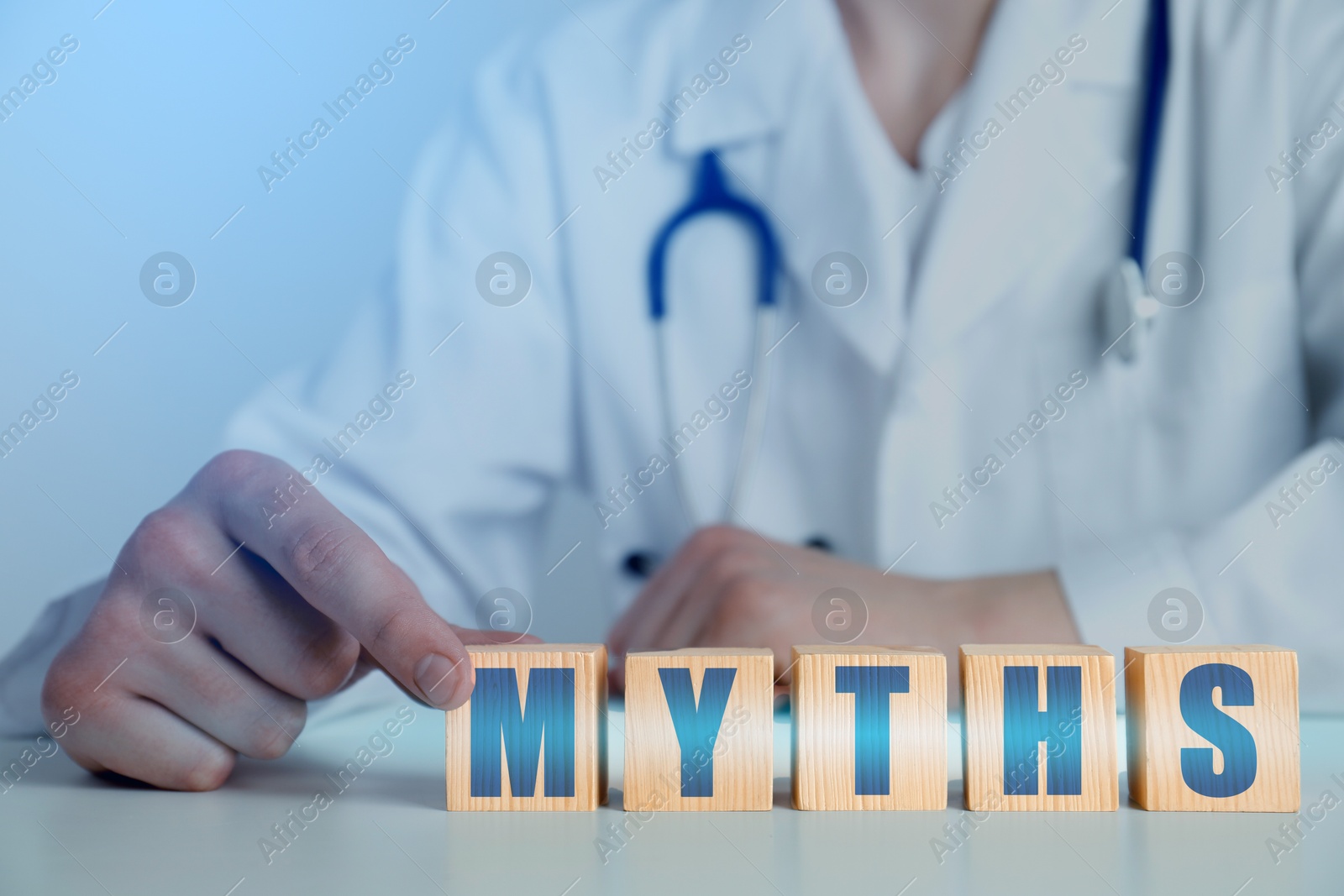 Image of Medical myths. Doctor making word of wooden cubes with letters, closeup