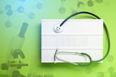 Image of Light box with stethoscope, top view. Light green background with molecular model and microscope