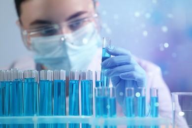 Image of Scientist holding test tube with sample in laboratory, selective focus