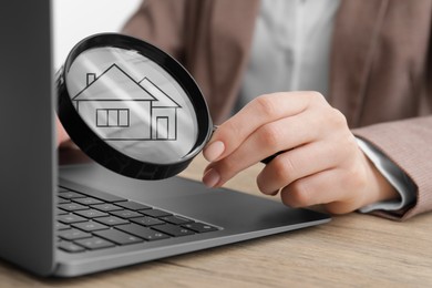 Image of Search for housing. Real estate agent holding magnifying glass with building icon over laptop, closeup