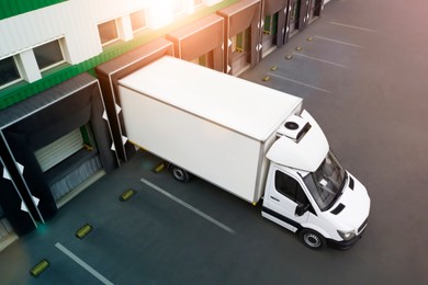 Image of Truck near loading dock of warehouse outdoors, aerial view. Logistics center