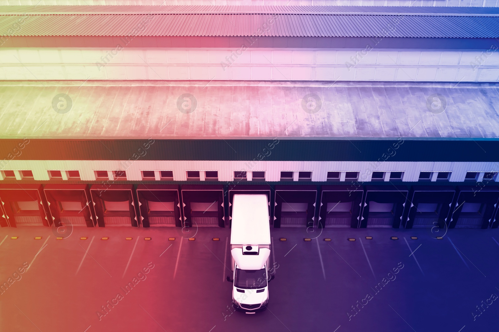 Image of Truck near loading dock of warehouse outdoors, color toned. Logistics center