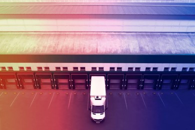 Image of Truck near loading dock of warehouse outdoors, color toned. Logistics center