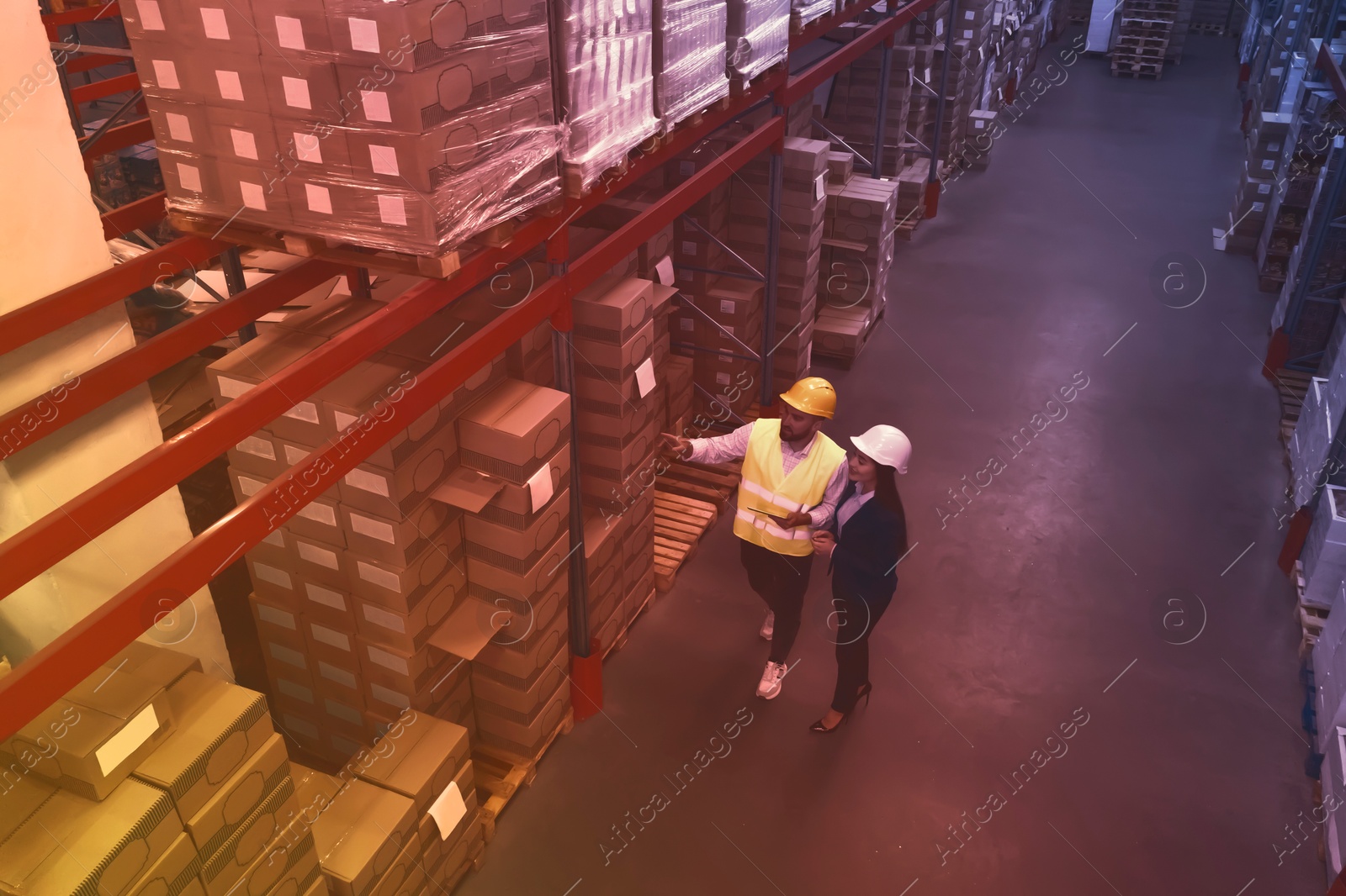 Image of Manager and worker at warehouse, above view. Logistics center. Color toned