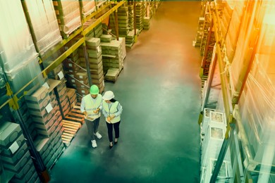 Manager and worker at warehouse, above view. Logistics center. Color toned