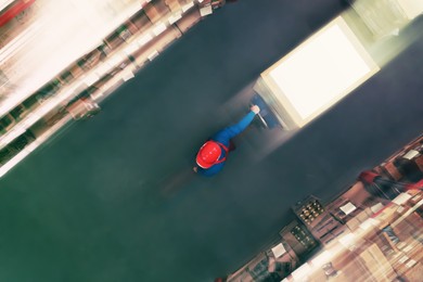 Image of Man working with pallet truck at warehouse, top view. Logistics center