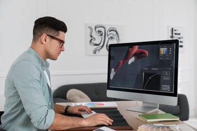 Professional retoucher working on computer in office