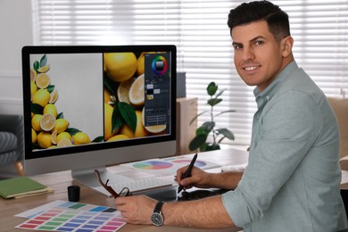 Professional retoucher working on computer in office