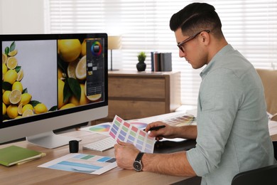 Professional retoucher working on computer in office