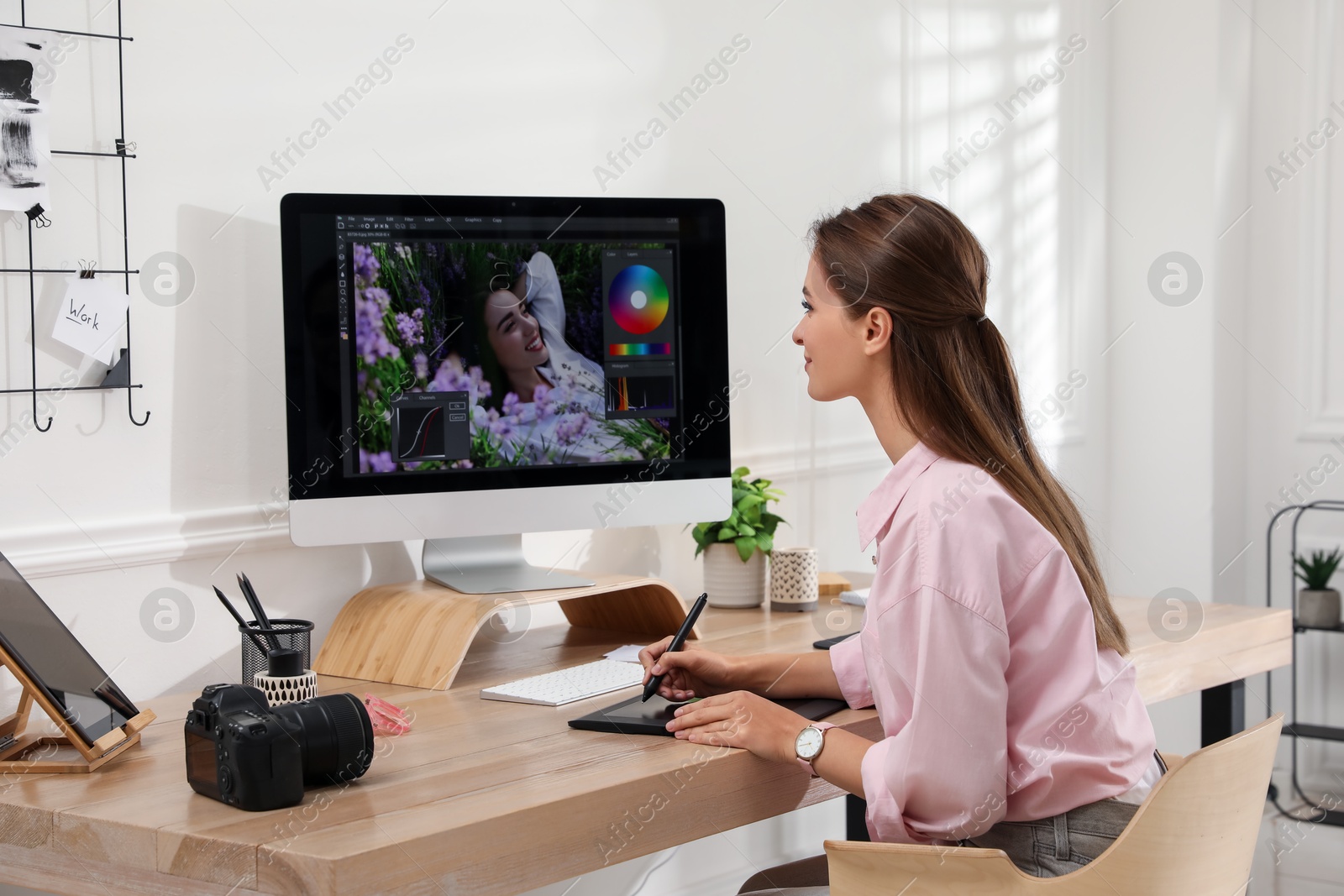 Photo of Professional retoucher working on graphic tablet at desk in office