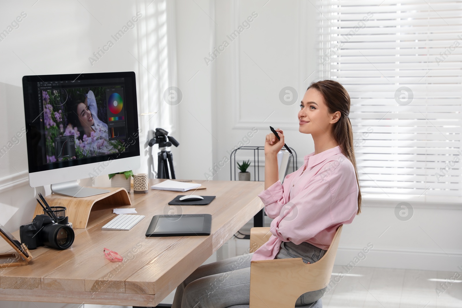 Photo of Professional retoucher working on graphic tablet at desk in office