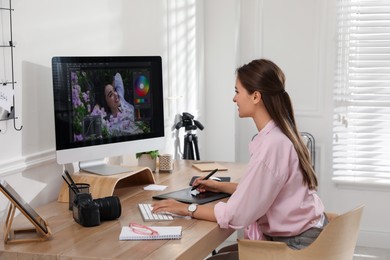 Photo of Professional retoucher working on graphic tablet at desk in office