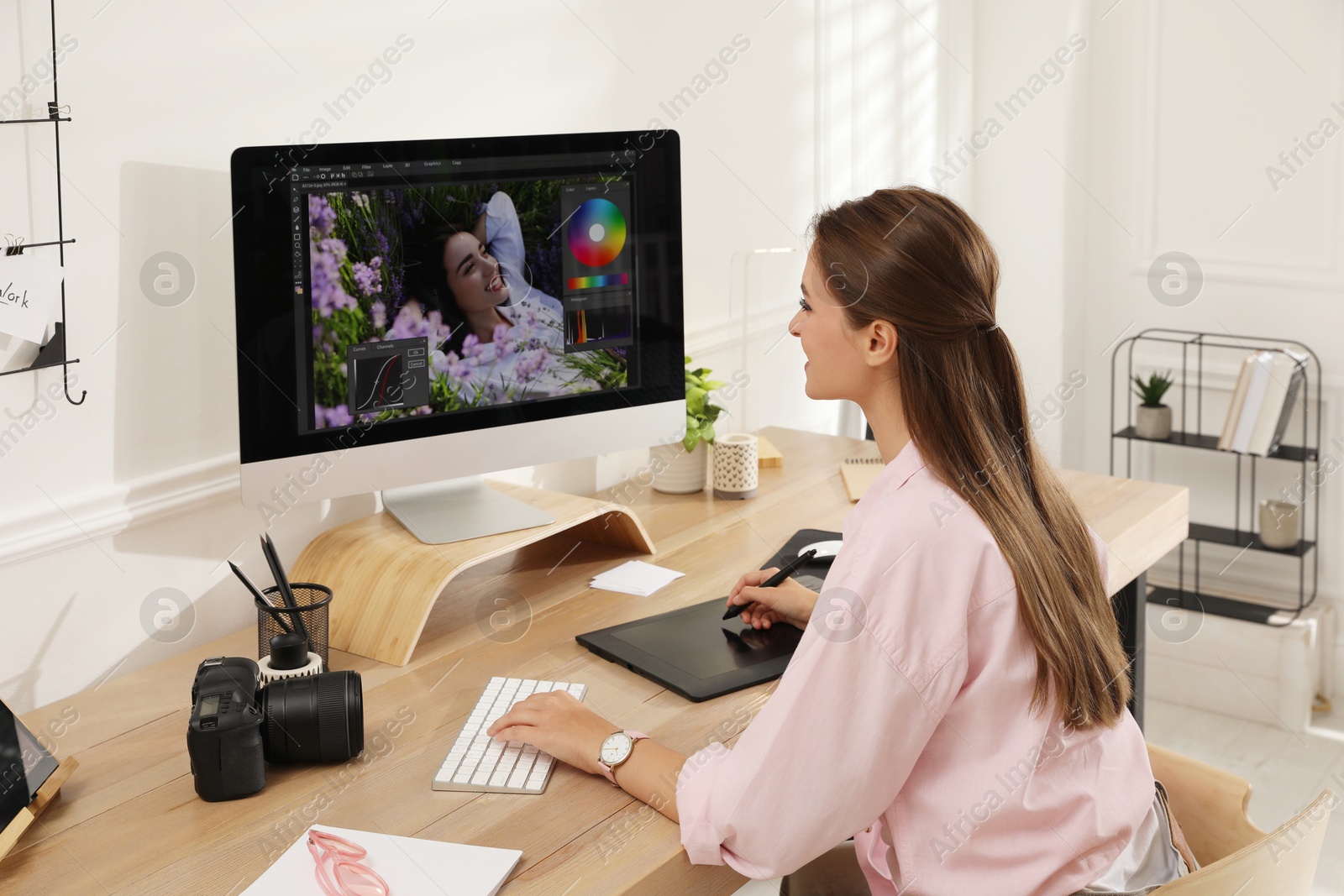 Photo of Professional retoucher working on graphic tablet at desk in office