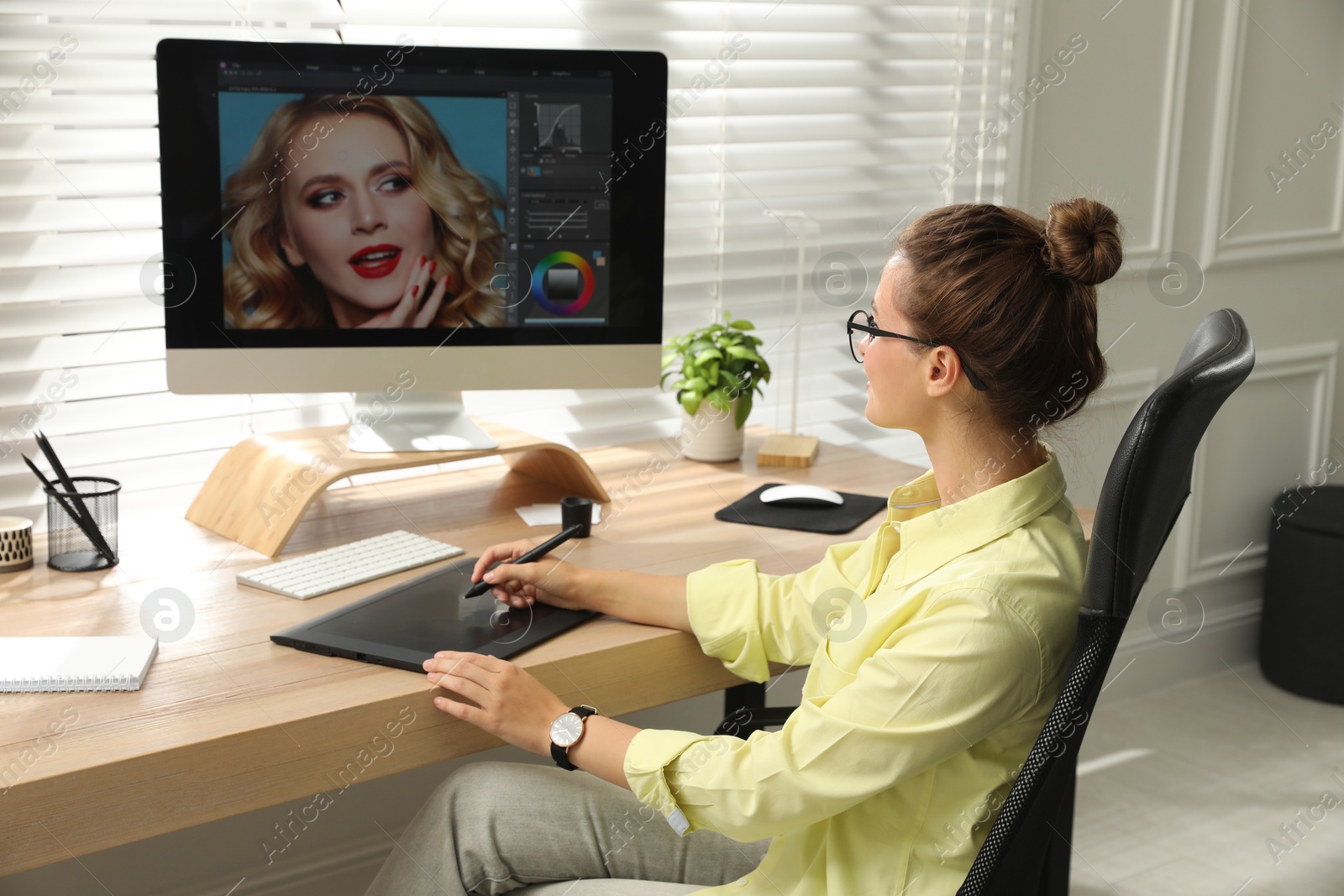 Photo of Professional retoucher working on graphic tablet at desk in office