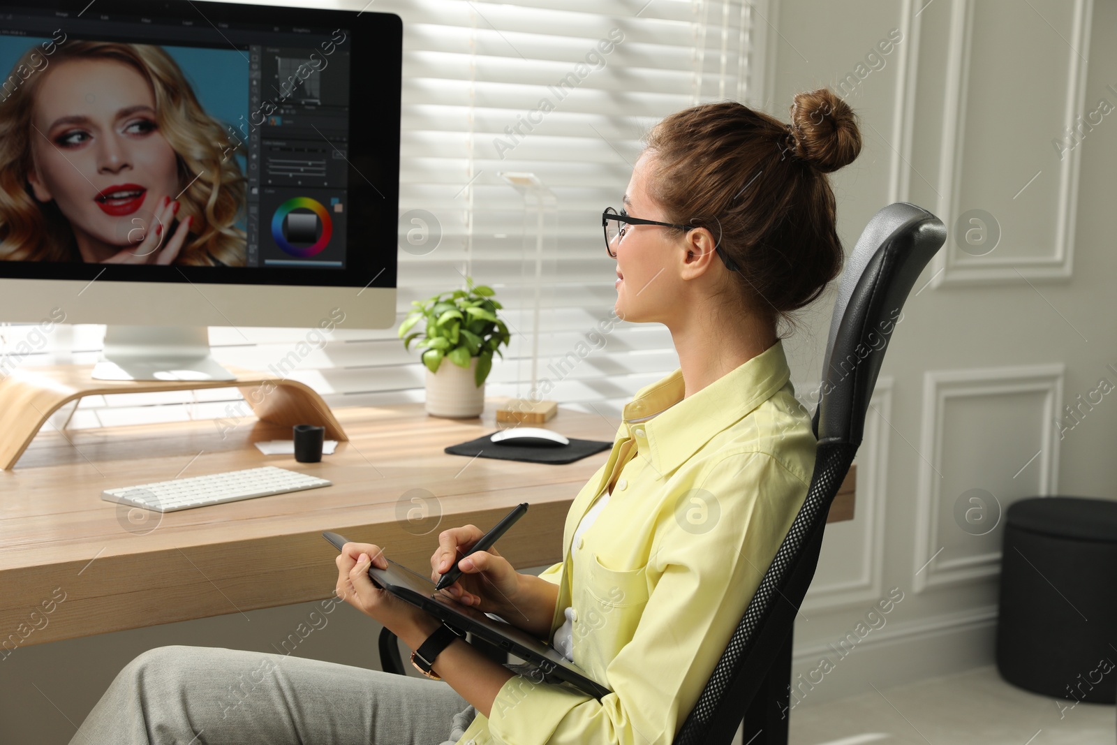 Photo of Professional retoucher working on graphic tablet at desk in office