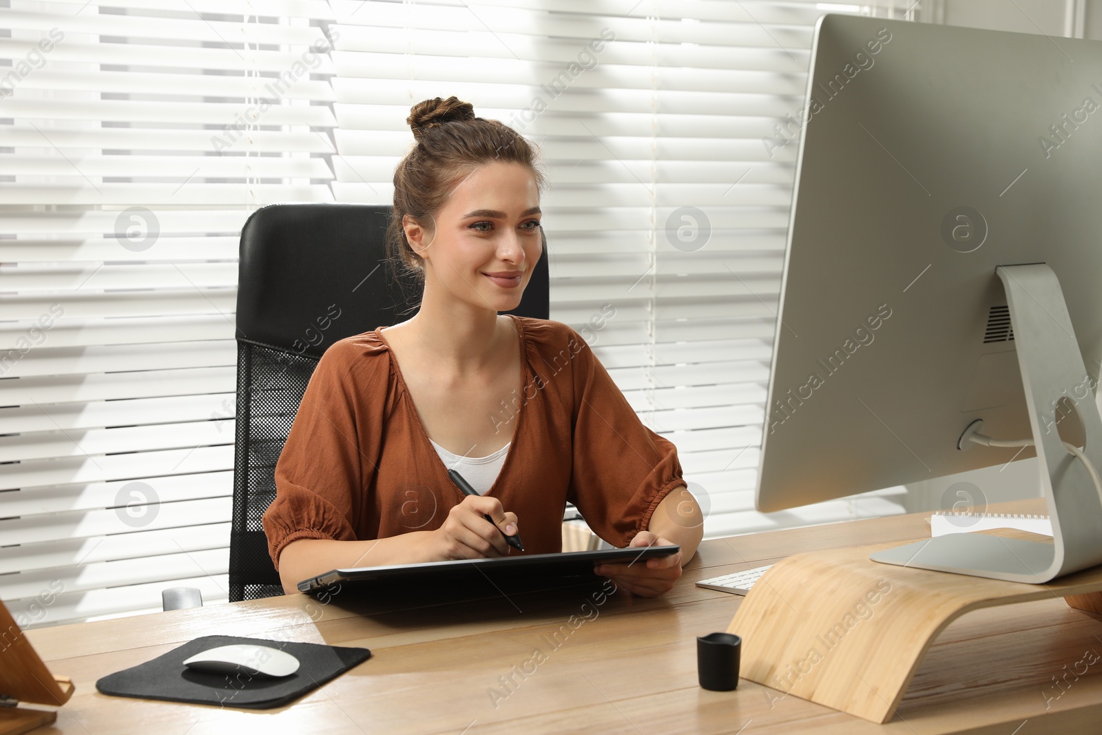 Photo of Professional retoucher working on graphic tablet at desk in office