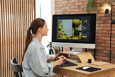 Photo of Professional retoucher working on graphic tablet at desk in office