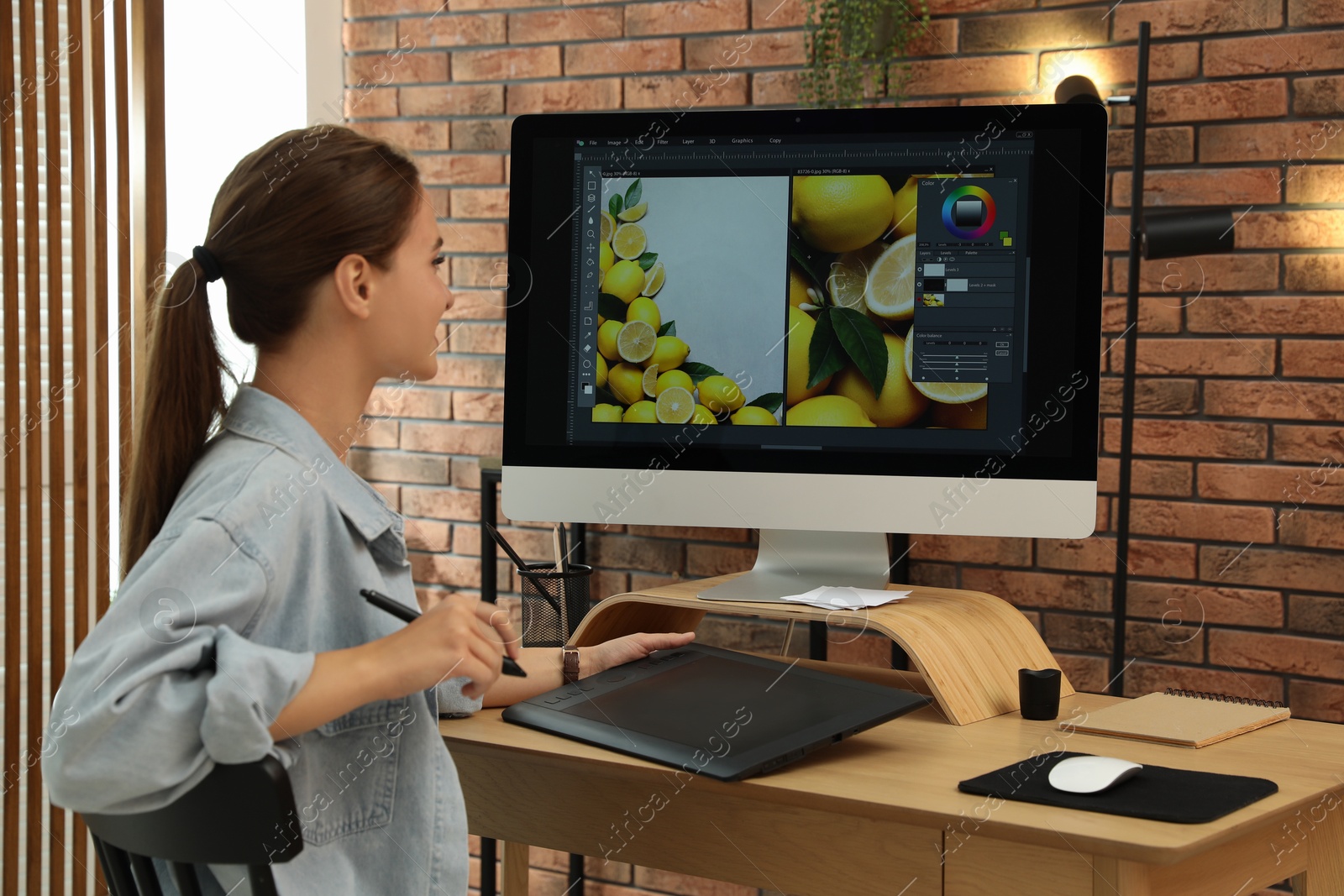 Photo of Professional retoucher working on graphic tablet at desk in office