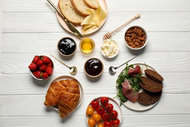 Photo of Different tasty food served for brunch on white wooden table, flat lay