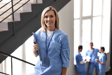 Photo of Smiling healthcare worker with clipboard in hospital