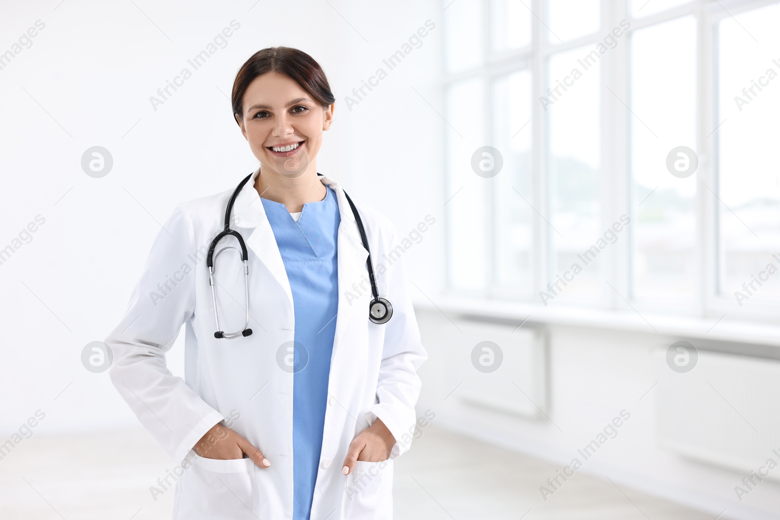 Photo of Smiling healthcare worker with stethoscope in hospital, space for text