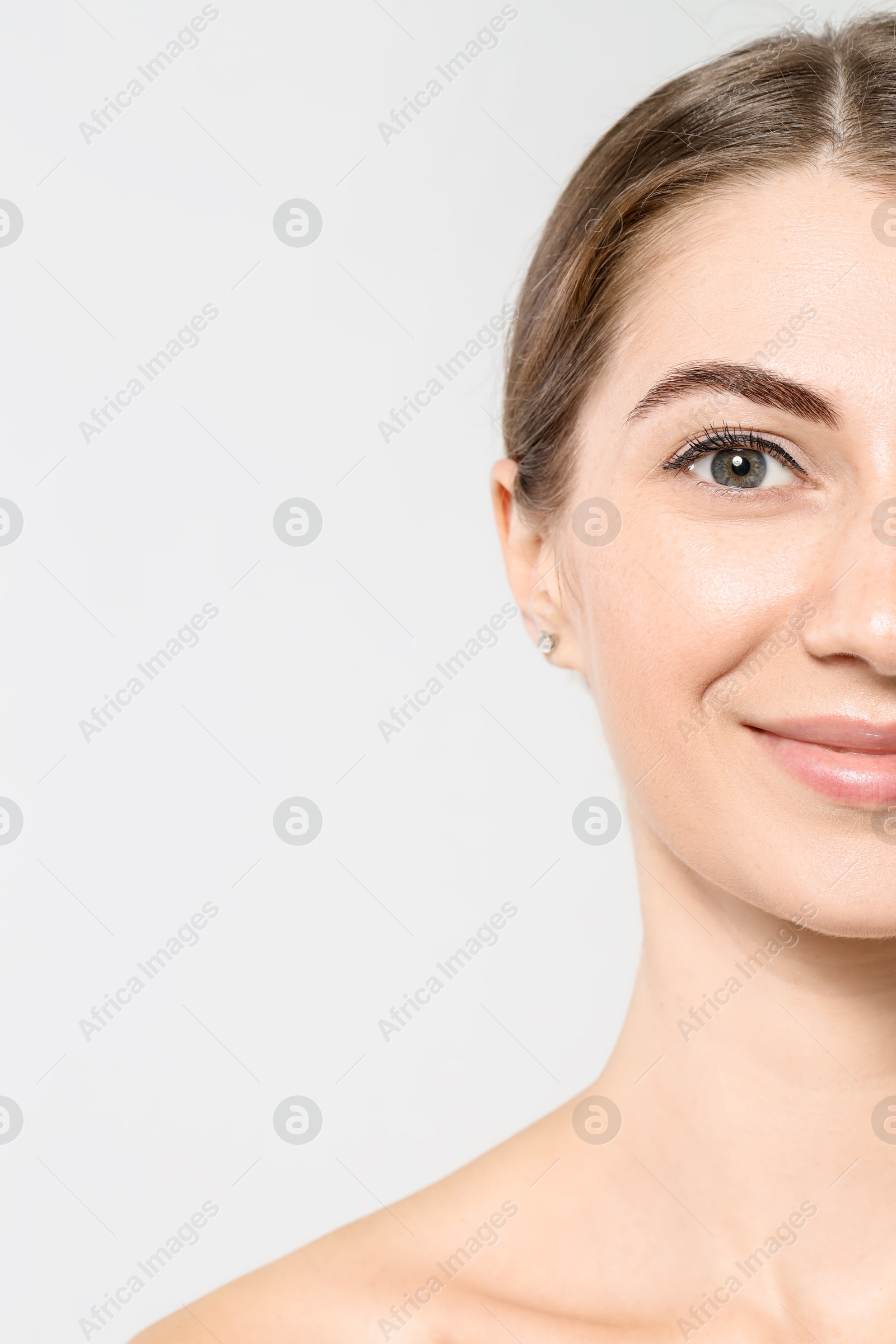 Photo of Beautiful young woman after henna eyebrows dyeing on light background, closeup