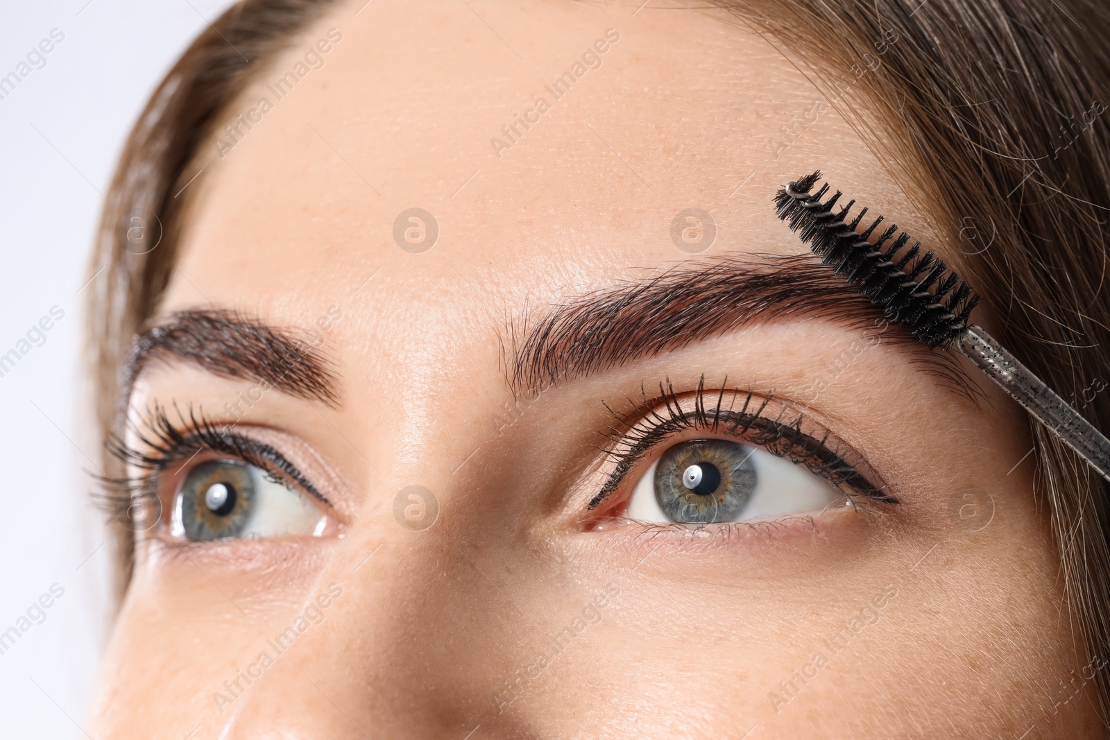 Photo of Beautiful young woman after henna eyebrows dyeing on light background, closeup