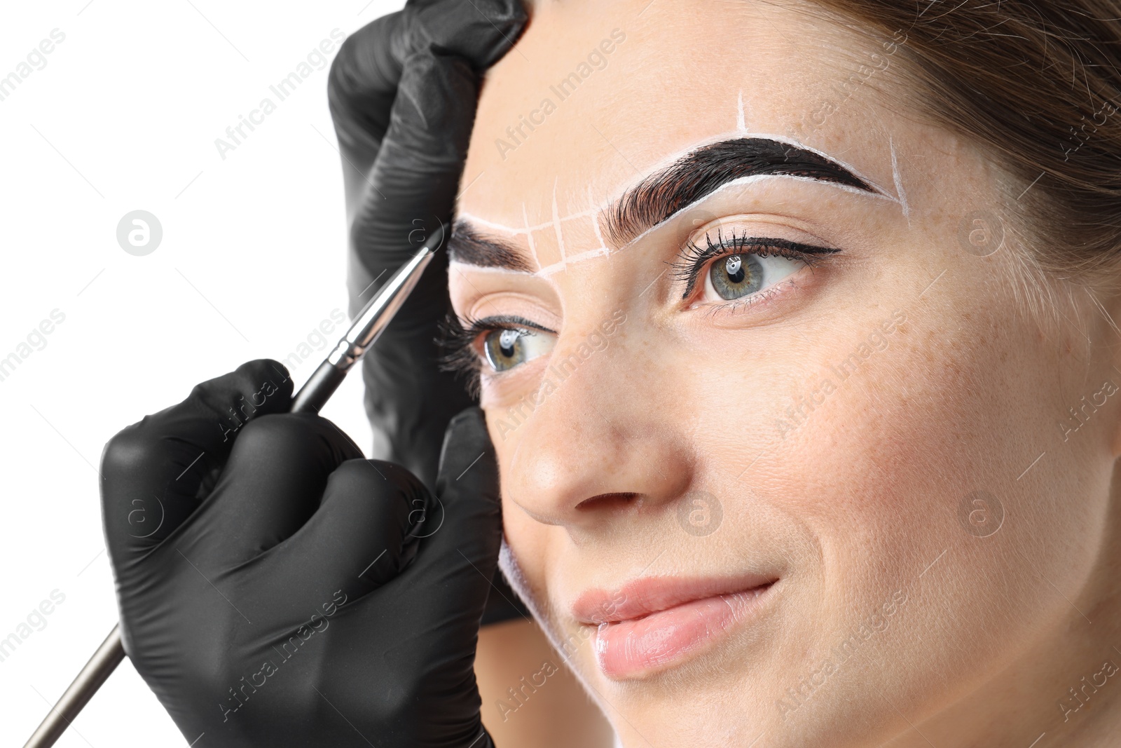 Photo of Young woman undergoing henna eyebrows dyeing procedure on light background, closeup