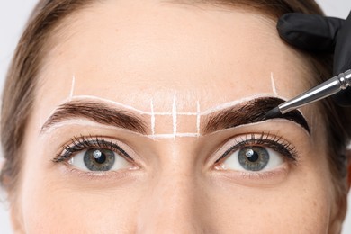 Young woman undergoing henna eyebrows dyeing procedure, closeup