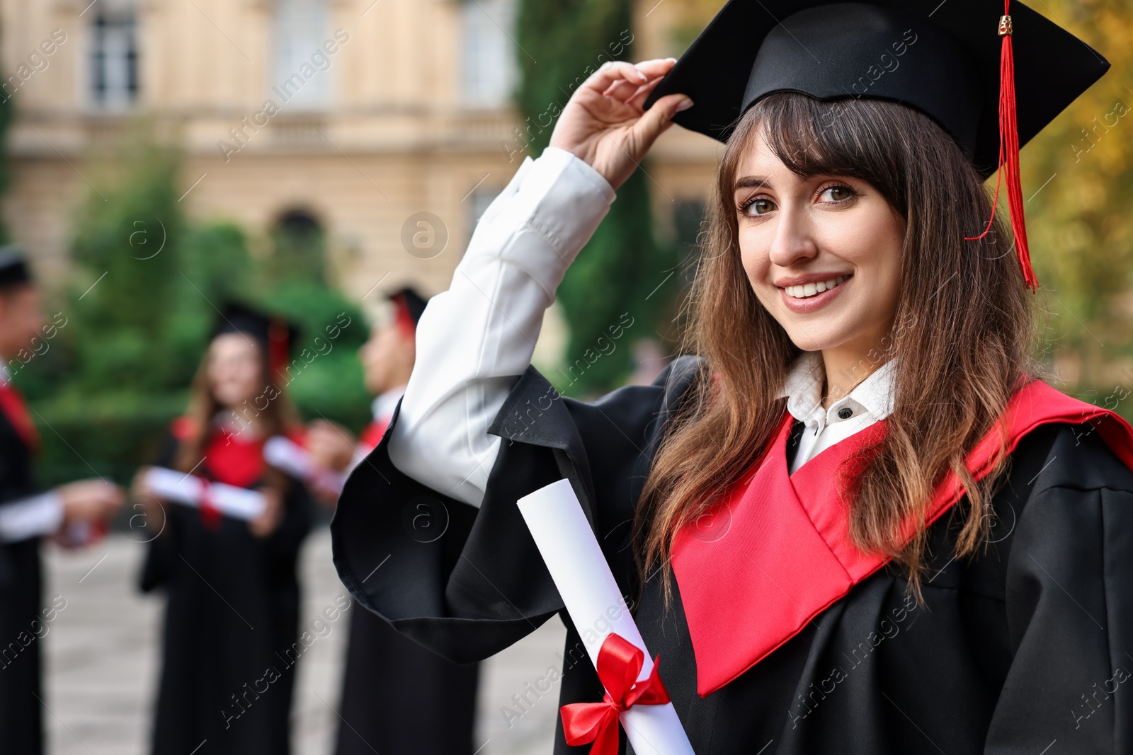 Photo of Happy students with diplomas after graduation ceremony outdoors, selective focus