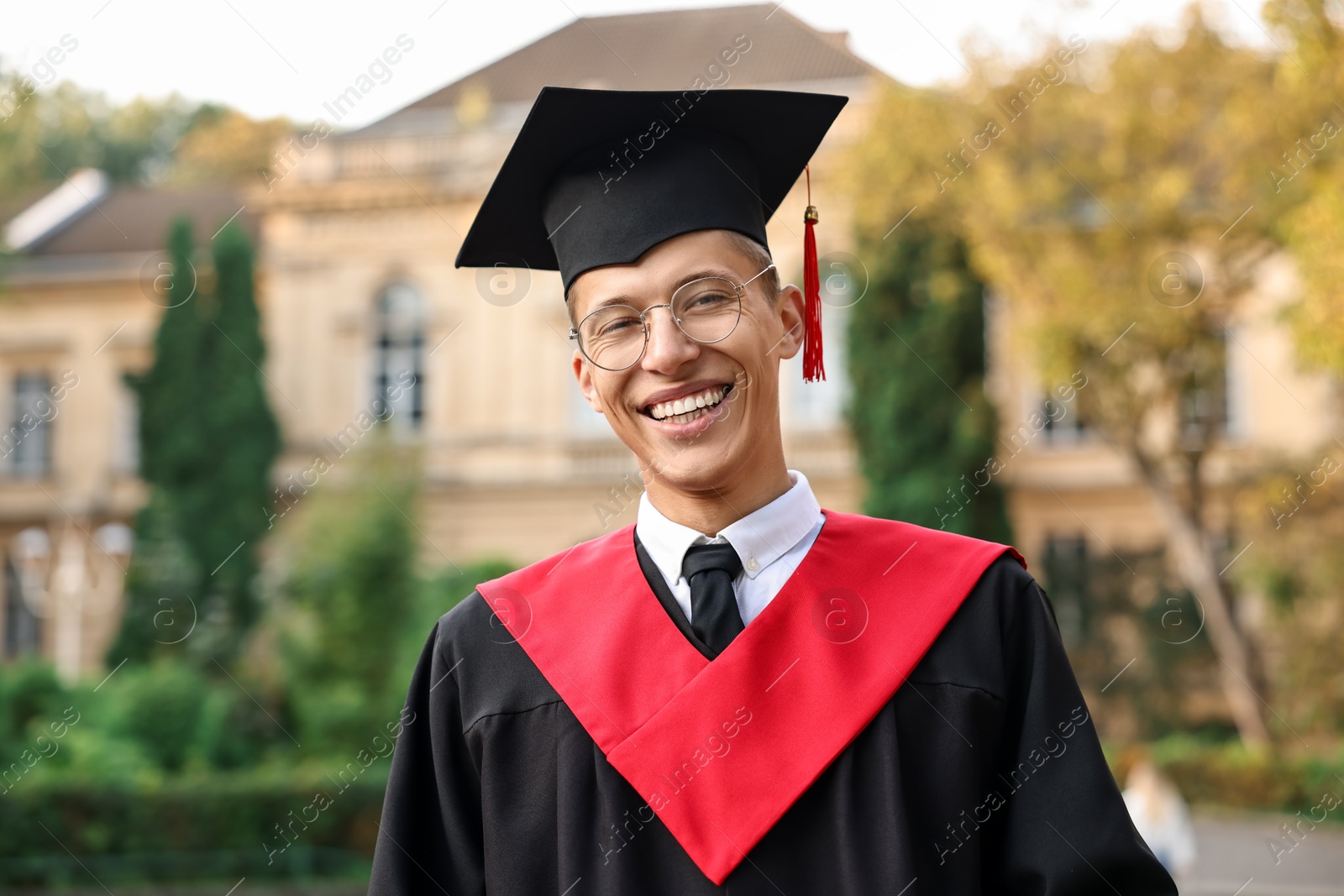 Photo of Graduation ceremony. Happy student in academic dress outdoors