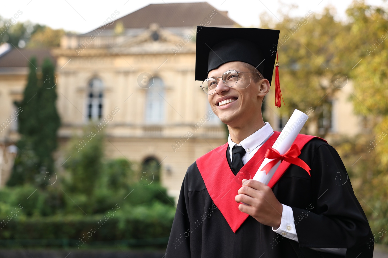 Photo of Happy student with diploma after graduation ceremony outdoors, space for text